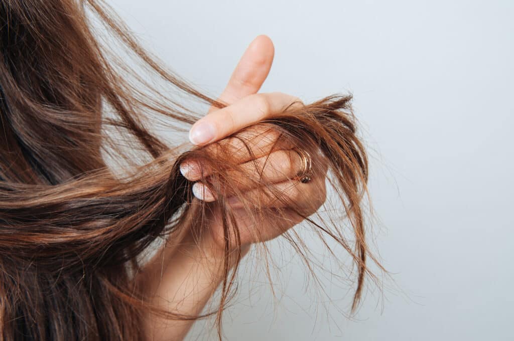 Girl holding her hair in her hand. Hair care concept. Shampoo. H